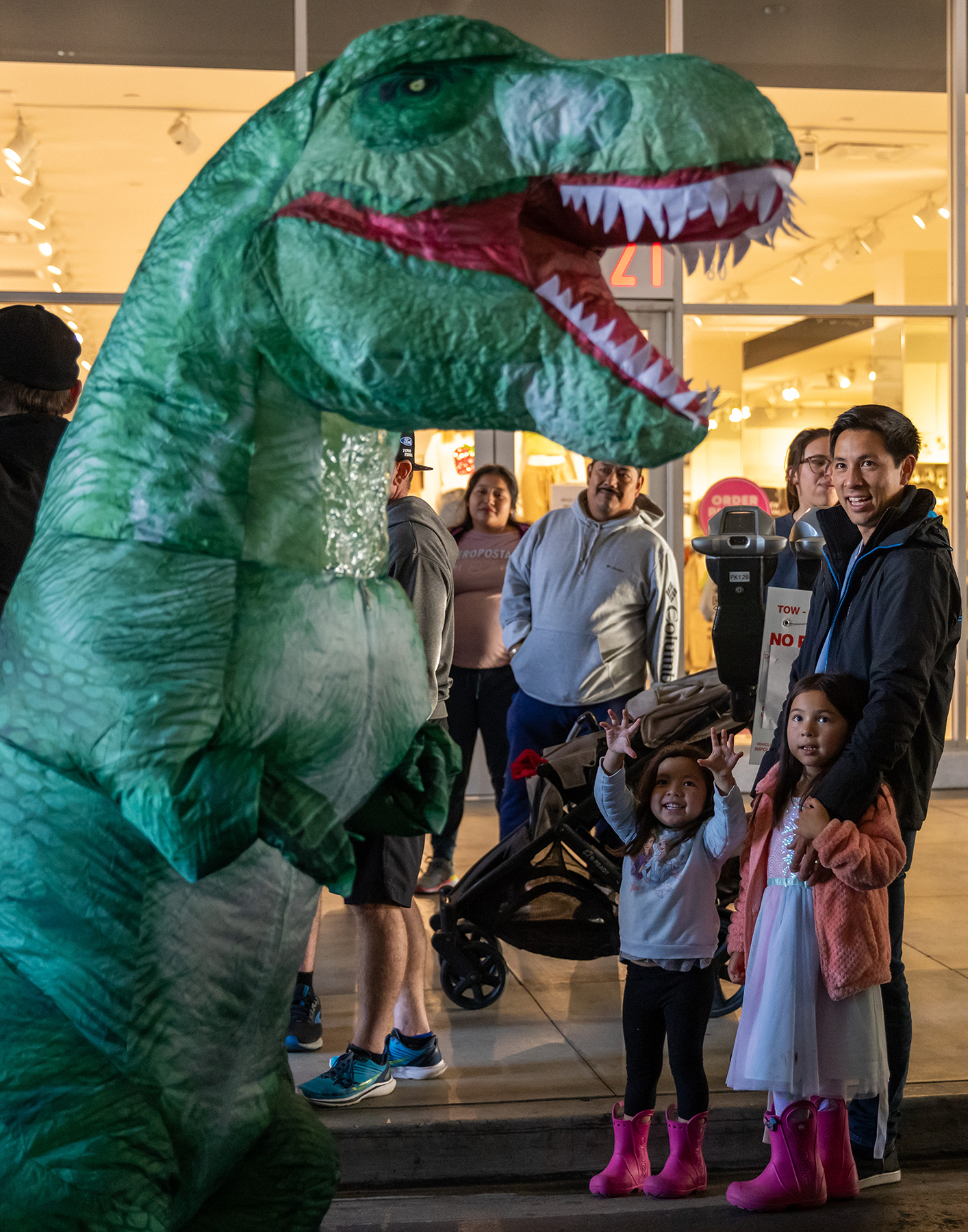 Moeko Zapata, 4, and family play along with Porsche’s “GT3Rawr” race car dinosaur during Thunder Thursday at the Pike Outlets.