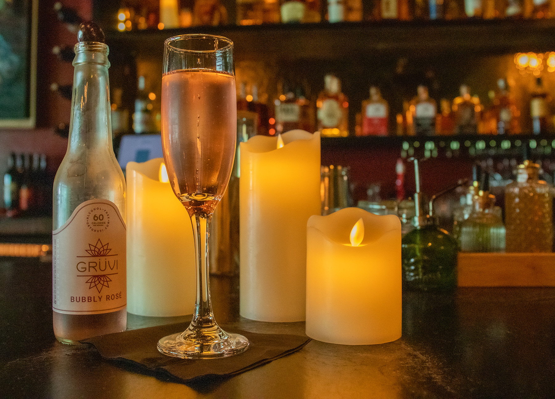 A full Champagne flute sits in front of LED candles.