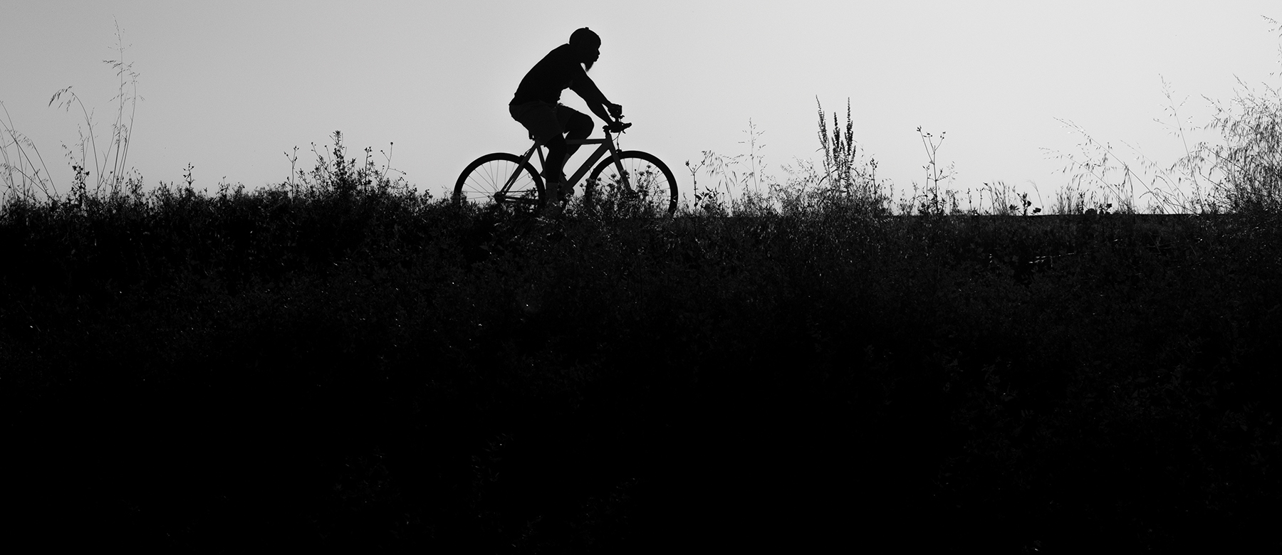 A black and white image showing the silhouette of a bike rider.