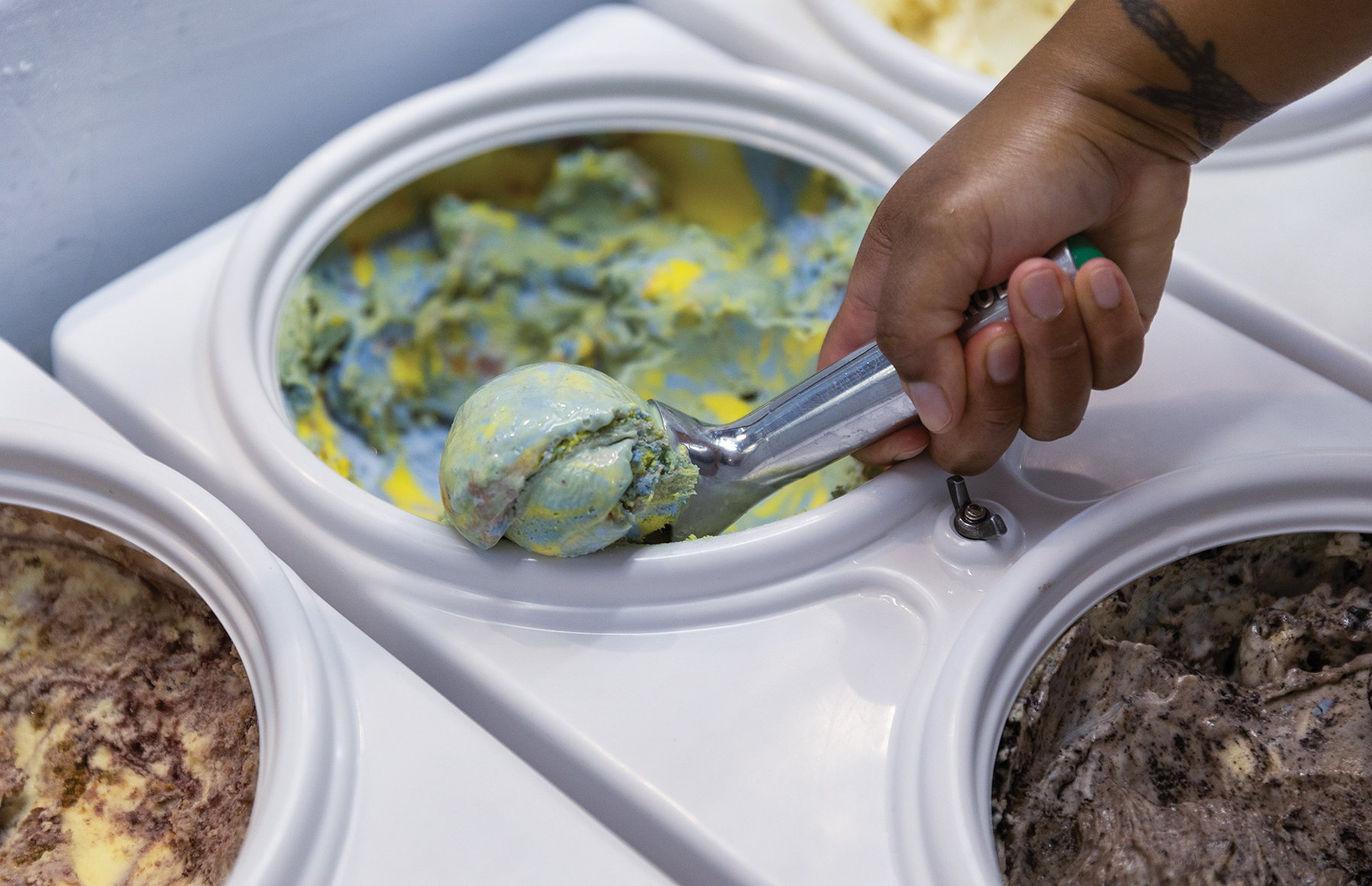 A hand is scooping ice cream.