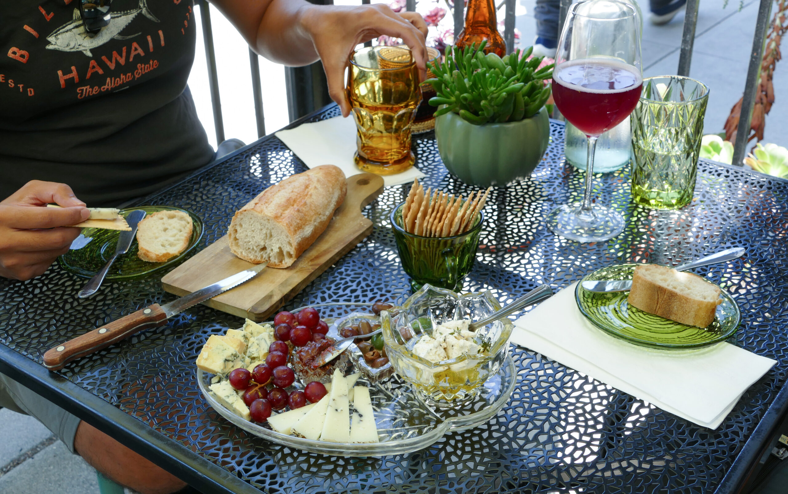 Two people enjoy a cheese flight, a beer and a glass of wine on the patio of The Vintage LBC in Bixby Knolls.