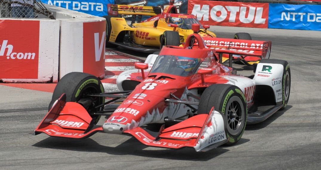 A red and white racecar drives down a track.