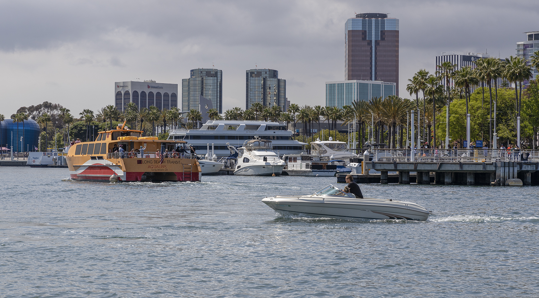 Boats move through the water backdropped by the Downtown Long Beach skyline.