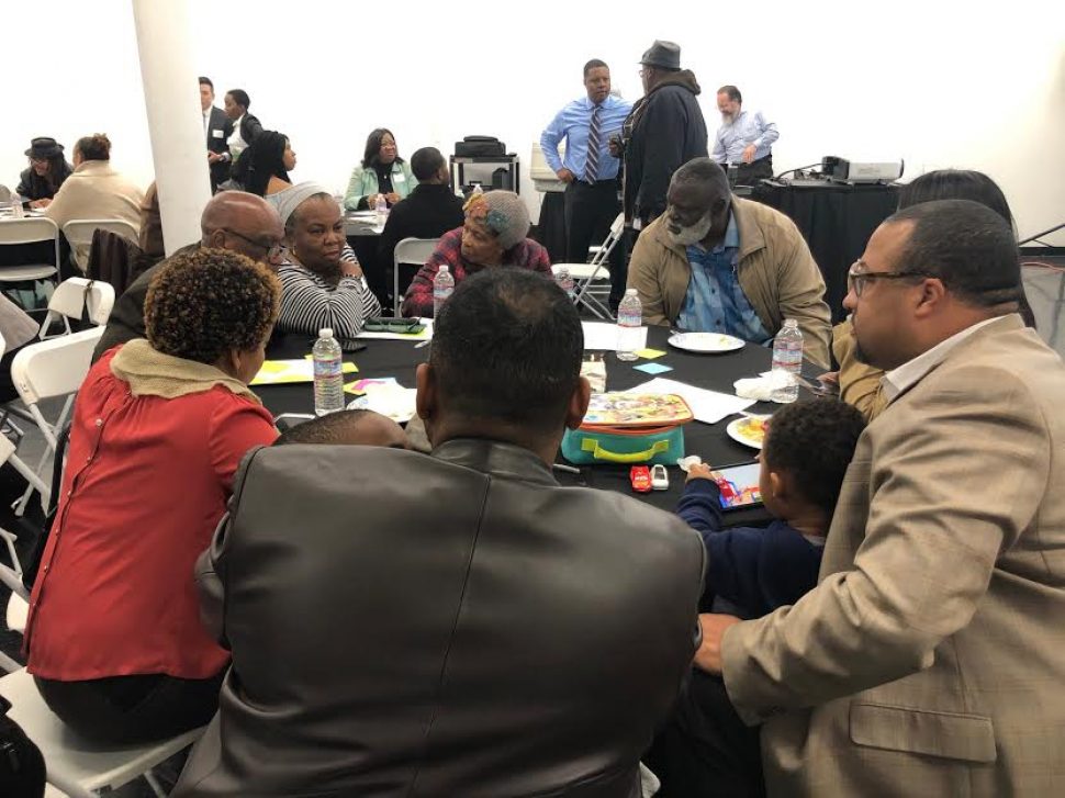 A group of about 10 people gather at a table to discuss ideas for a proposed African American Cultural Center.