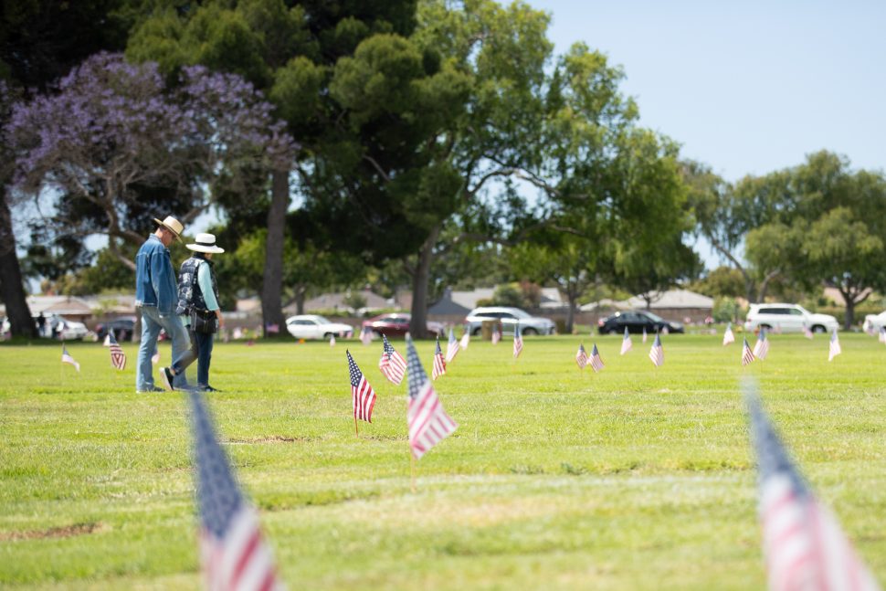 A couple leaves, walking by graves that had Memorial Day flags placed at the Forest Lawn grave sites in Long Beach Monday, May 27, 2019. Photo by Kelly Smiley